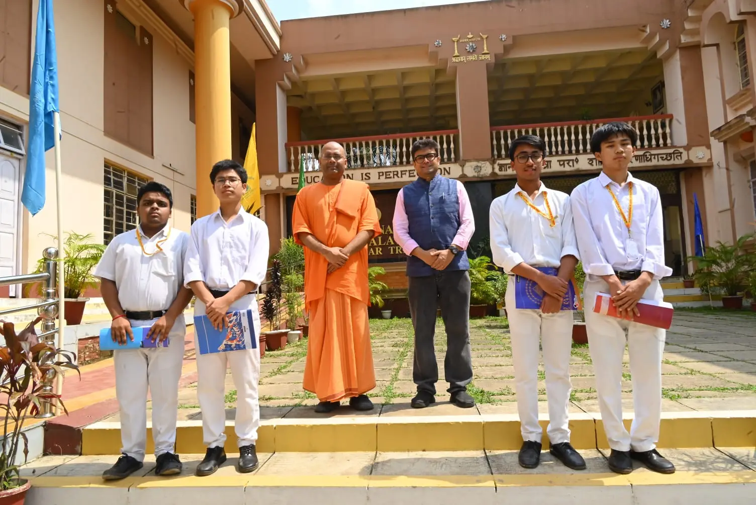 Dr. Jayanta Ghosh with students and a monk outside Ramakrishna Mission Vidyalaya after a career clarity session